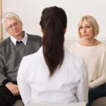 Doctor talking to senior couple at home