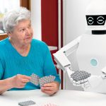 ambient assisted living service robot is playing a card game with a senior adult woman, concepts like robotic caregiver in the household or old folks home